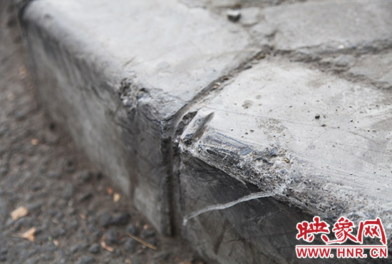 車(chē)道邊上的臺(tái)階，滿是電動(dòng)車(chē)摔下碰撞的痕跡