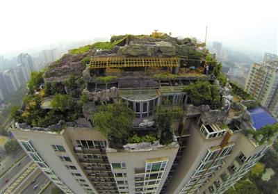 　　昨日，身穿橘黃色馬甲的工作人員在人濟(jì)山莊樓頂拆除違章建筑。新京報(bào)記者 吳江 攝
