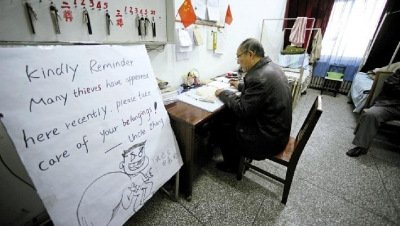 張大爺在門衛(wèi)室里工作，旁邊是紅爆網(wǎng)絡(luò)的溫馨提示牌記者