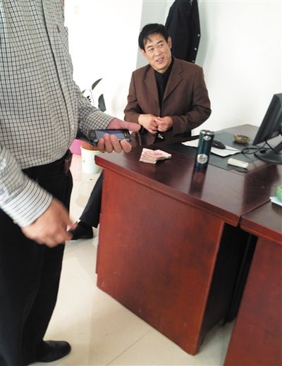 10月29日，獻縣國稅局稽查局辦公室內(nèi)，一名企業(yè)主交了兩萬元現(xiàn)金在桌上。新京報記者 孟祥超 攝