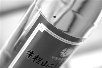 圖中畫(huà)圈處為瓶中的黑色異物。京華時(shí)報(bào)記者 譚青 攝