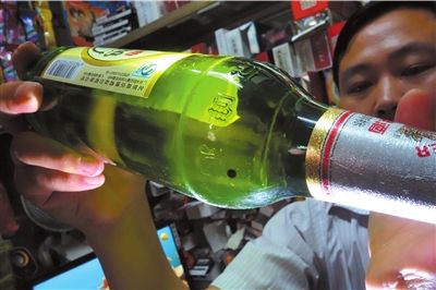 這瓶未開封的燕京啤酒內(nèi)有一顆黑色懸浮物。京華時報記者 徐曉帆 攝