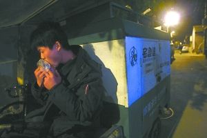 快遞哥抽空吃兩口東西。記者 李剛 攝
