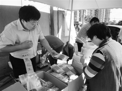 昨日，河南企業(yè)家劉春喜在京“練攤”，為顧客挑選綠豆。新京報(bào)記者 張玉學(xué) 攝
