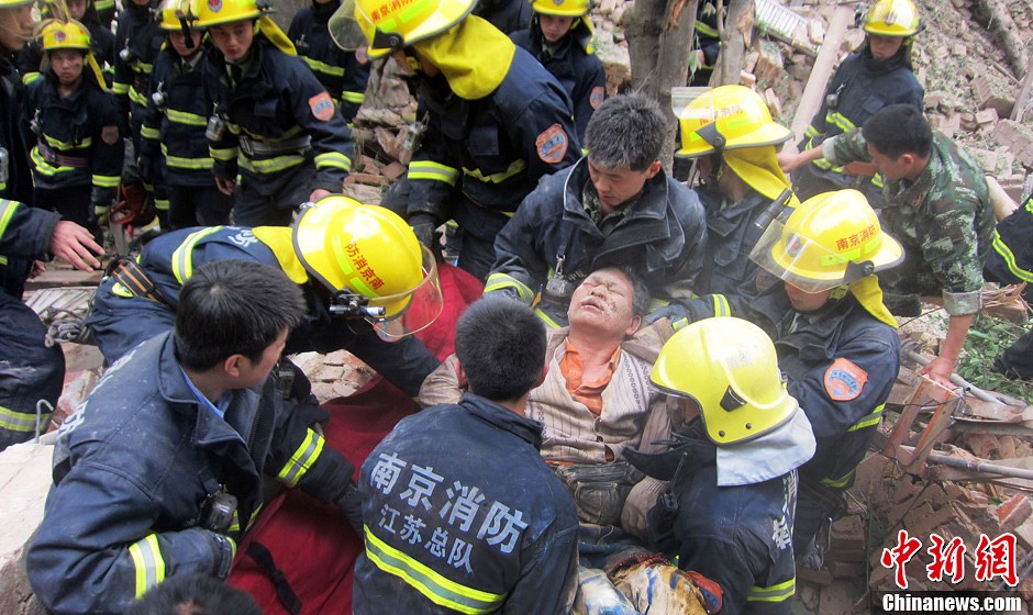 圖為南京消防隊員從廢墟中將傷者抬出。中新社發(fā) 梅亮 攝