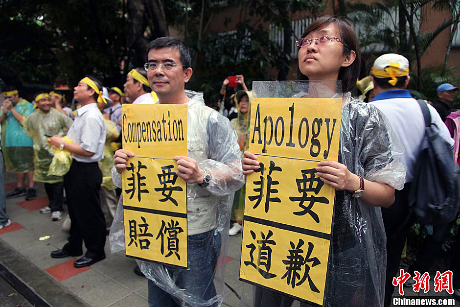 　圖為當(dāng)天下午，當(dāng)臺(tái)灣數(shù)百漁民在馬尼拉經(jīng)濟(jì)文化辦事處前抗議時(shí)，有兩名年輕人手持標(biāo)語，在路邊聲援。中新