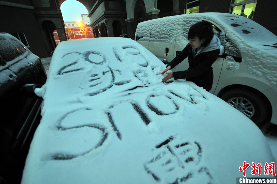 11月18日，行人在車輛的積雪上涂鴉。