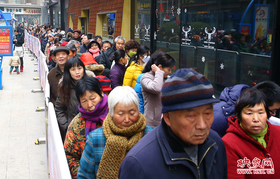 領(lǐng)粥的市民排起了長隊，足有上千人。