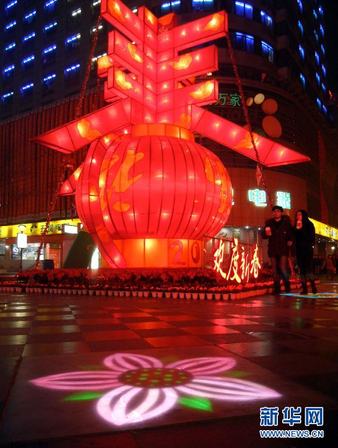 　1月30日晚，市民從蘇州市石路銀河廣場上大型“春”字彩燈景觀旁經(jīng)過。