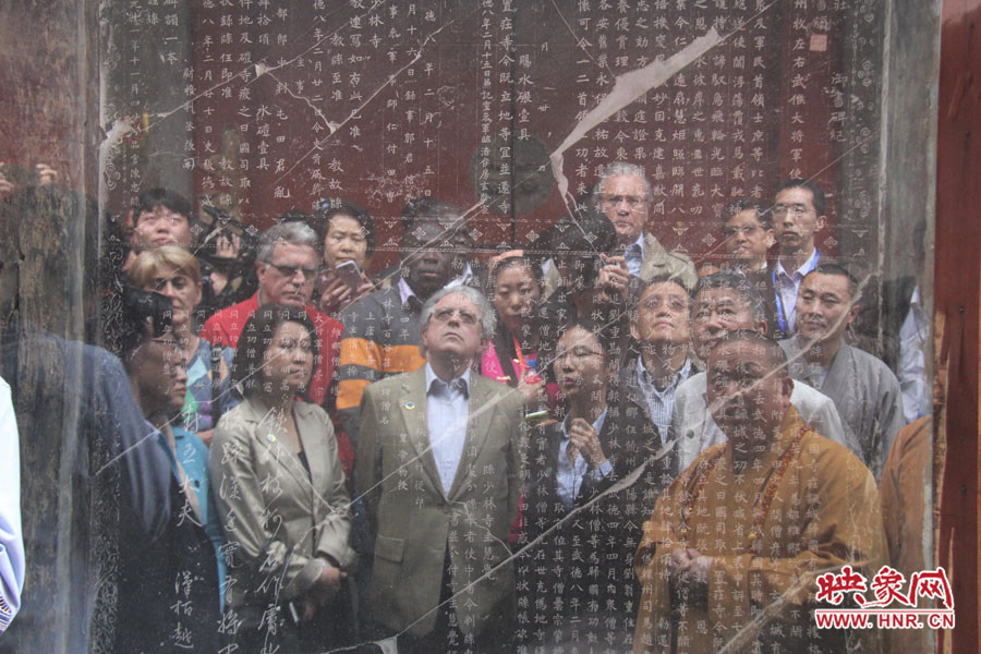 在一塊石碑前，少林寺方丈正在講解