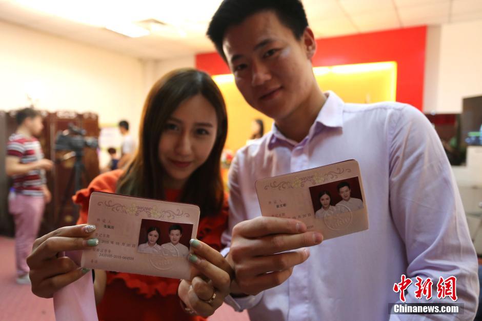5月20日,河南鄭州,一對(duì)準(zhǔn)新人領(lǐng)完結(jié)婚證后秀自拍。