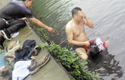 網(wǎng)友貼出民警張光聰一出河水就睜不開眼，用手抹去臉上臟水的照片。