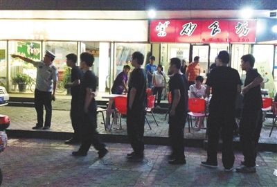 6月13日晚10點，朝陽區(qū)國美第一城附近，一名城管隊員帶領(lǐng)一隊協(xié)管例行巡查街邊大排檔。新京報記者 尹亞飛 攝