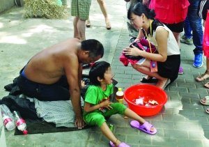 記者找到小女孩時(shí)，男子正帶著她在中央路上乞討 記者 施向輝/攝