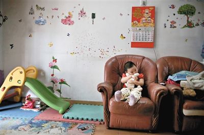6月14日，未婚媽媽于軍的家里。女兒悅悅抱著兔子玩偶，在聽媽媽手機上的兒歌，這個4歲女孩喜歡兔子。