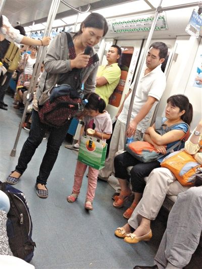 6月27日，舒馨帶一女孩在地鐵十號線行乞。她因被疑帶多個不同小孩乞討被警方搜尋。新京報記者 申志民 攝