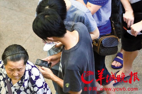 排隊的“黃?！备魇謭?zhí)一疊白紙，上面寫好了要掛號的人的信息，包括姓名、電話、要掛的科室等。穿黑白花紋衣服的老婆婆正在排隊掛號