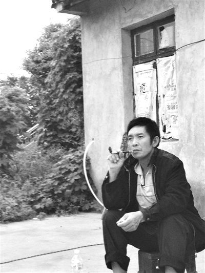 9月12日，陳文才在自己的出租屋旁抽煙。新京報(bào)記者 朱柳笛 攝