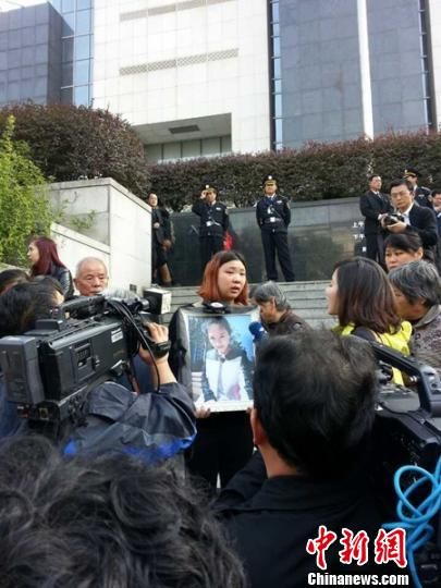 法院外，死者祁某的家人正在接受媒體采訪。 田雯 攝