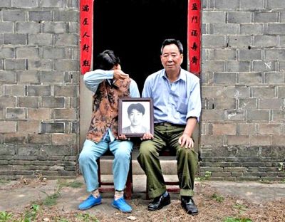 江蘇鎮(zhèn)江，老劉夫婦捧著獨(dú)生子的遺像在老家前留影南方都市報(bào)供圖L