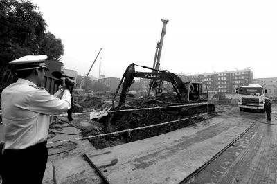 學(xué)院南路一科研樓項目有3臺挖掘機違規(guī)進行土方作業(yè)，被城管隊員當(dāng)場責(zé)令停工。京華時報記者歐陽曉菲攝