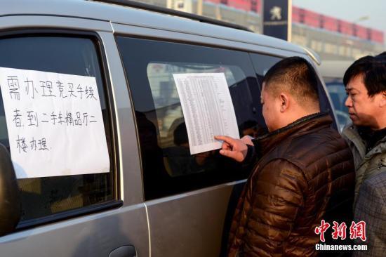1月23日，北京亞運(yùn)村汽車交易市場中拓拍賣停車場上人頭攢動(dòng)，市民查看拍賣車輛信息。