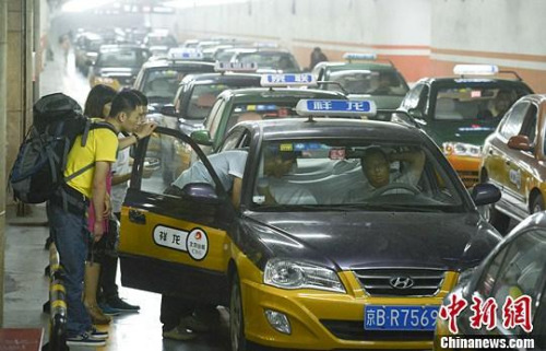 市民在北京西客站出租車候車點準備乘車。中新社發(fā) 侯宇 攝