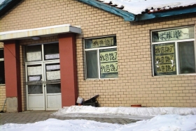伊春市帶嶺區(qū)一排破舊的平房，房間窗戶上貼滿了“我告饒了”的字樣。