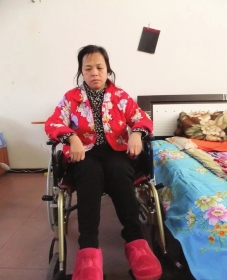 陳慶霞坐在輪椅上。她現(xiàn)在下身癱瘓，疾病纏身，生活不能自理。