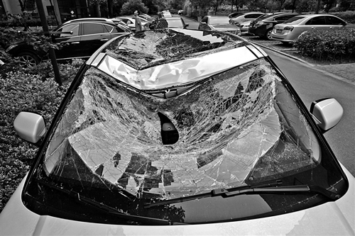 越野車車蓋以及前擋風(fēng)玻璃被砸得凹陷進(jìn)去。見習(xí)記者姚卡/攝