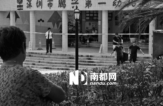 →7月19日，鵬興花園第一幼兒園門前，民警在現(xiàn)場(chǎng)進(jìn)行完勘查取證后，園長(zhǎng)和保安的尸體被運(yùn)走。南都記者 徐文閣 攝