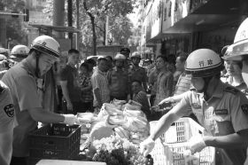 7月11日，瀏陽市北正中路，執(zhí)法人員暫扣張海的水果。這是瀏陽市城管局拍攝的執(zhí)法現(xiàn)場圖。