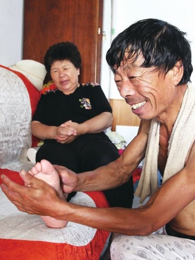 慈成富為老伴按摩。
