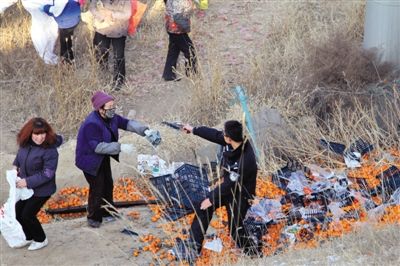 1月4日，連霍高速蘭州市榆中縣和平鎮(zhèn)段，一名警察舉著槍驅(qū)散哄搶橘子的村民。圖/CFP