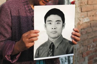 5月19日，朝陽(yáng)北路，母親捧著張東文的遺像。新京報(bào)記者 侯少卿 攝