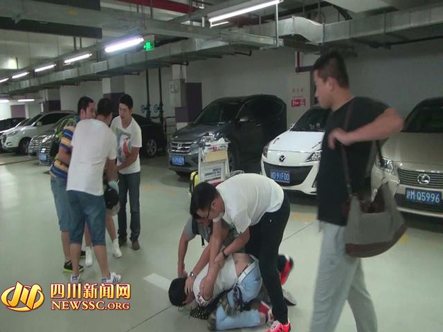 辦案人員在機(jī)場(chǎng)停車場(chǎng)抓獲胡某及其女友（警方視頻截圖）。