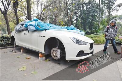 昨日，停放在重慶大學(xué)B區(qū)的一輛瑪莎拉蒂豪車(chē)被架在幾塊磚頭上，車(chē)輪不翼而飛。 重慶晨報(bào)記者 胡杰 攝