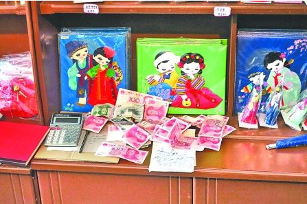 　　2012年6月21日，在朝鮮羅先特別市的一家商店里，柜臺(tái)上散落著一些人民幣。在朝鮮，人民幣比本國(guó)