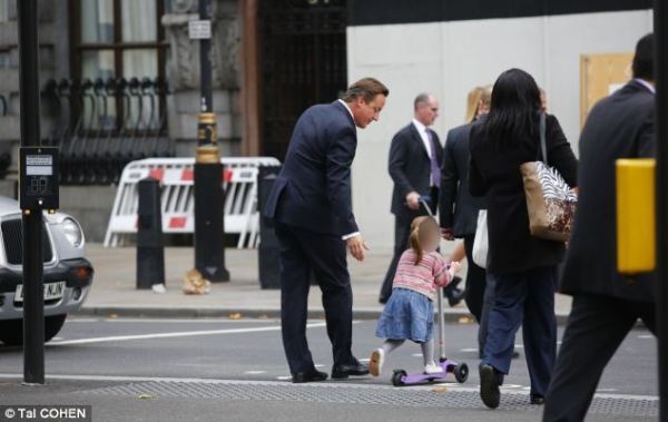 英國(guó)首相卡梅倫步行送女兒上幼兒園。