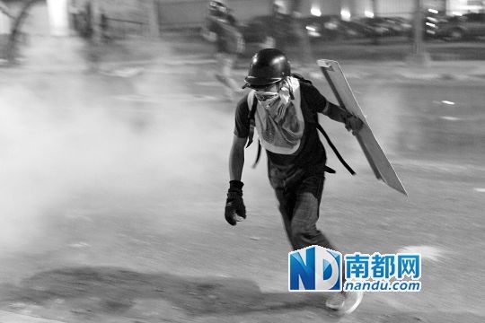 反政府示威者在與警察的沖突中躲避催淚彈。