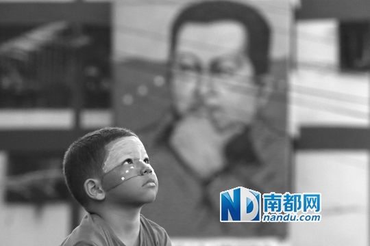 3月5日，一名委內(nèi)瑞拉兒童仰望天空，他身后是查韋斯的陵墓。