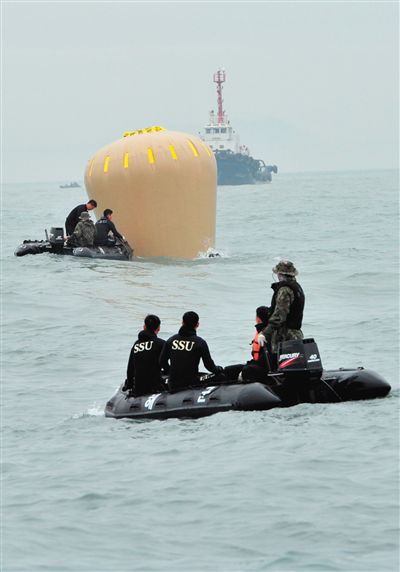 18日，搜救人員準備將氣囊捆綁到沉沒客輪上。