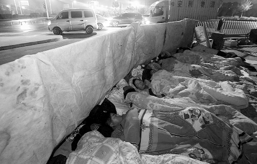在寒冷的冬夜，為了能省點(diǎn)錢，方便接活，民工們?nèi)运跇蛳隆? complete=