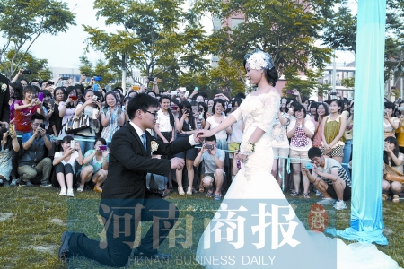 在學(xué)校操場的草坪上，兩名畢業(yè)生舉行婚禮，有同學(xué)感動(dòng)地抹起眼淚