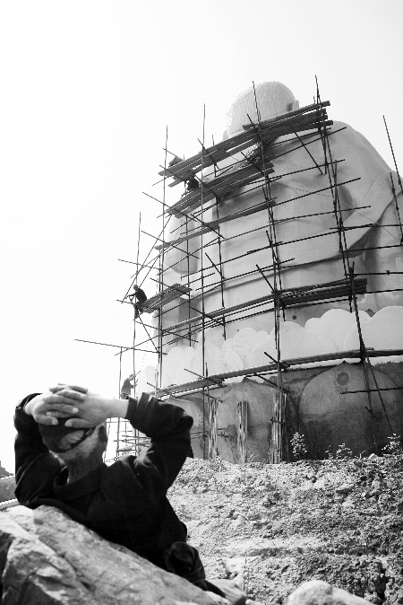 今年4月26日，工作人員將帆布蓋在“佛像”頭像上