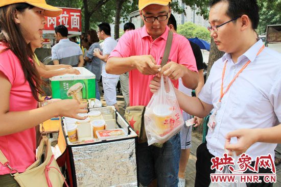 圖為徐貴雨和一名勤工助學(xué)的學(xué)生在街頭義賣快餐。