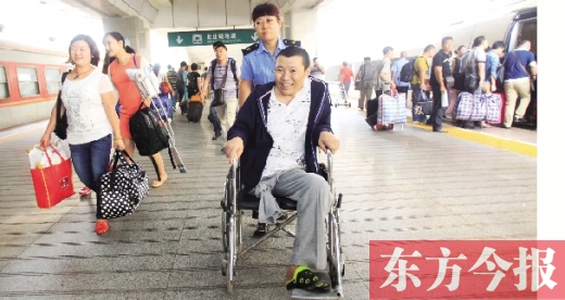 李剛手術(shù)后歸來(lái)，在車站工作人員幫助下走出鄭州火車站站臺(tái)  東方今報(bào)首席記者 張曉冬 攝