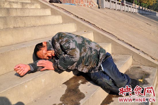 這名男子的衣服以及褲子全濕透了，水從衣褲里流出來，嘴里散發(fā)著濃烈的酒氣。