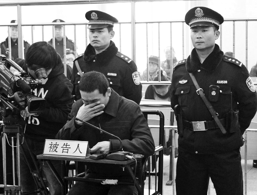 庭審中,29歲的李軍低著頭。