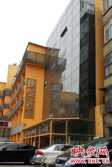 該酒店為加蓋樓層統(tǒng)一安裝上黑色玻璃，從前面看不出加蓋的痕跡